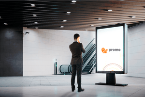 Hombre de traje viendo una pantalla de Promo Espacio y analizando la compra de publicidad para tener un presupuesto ganador